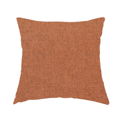 The fabric used to create this handmade cushion is a finely textured weave in a bright ginger, amber, or light rust shade. The material features a subtle heathered look with finely blended threads of warm orange and darker neutral undertones throughout.