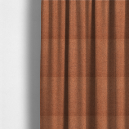 The fabric used to create these made-to-measure curtains is a finely textured weave in a bright ginger, amber, or light rust shade. The material features a subtle heathered look with finely blended threads of warm orange and darker neutral undertones throughout.
