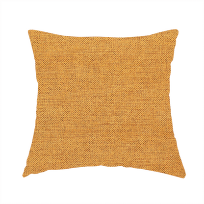 The fabric used to create this handmade cushion is a finely textured weave in a rich mustard yellow or golden-amber shade. The material features a subtle heathered look with finely blended threads of warm yellow and darker neutral undertones throughout.