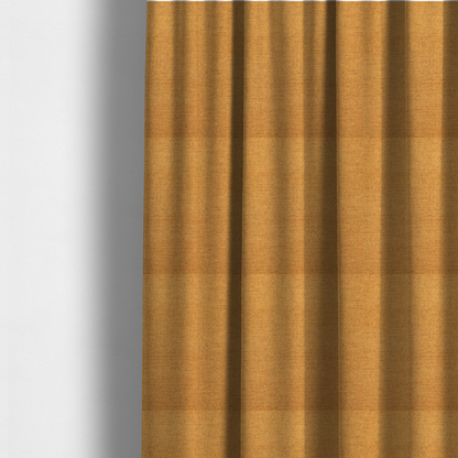 The fabric used to create these made-to-measure curtains is a finely textured weave in a rich mustard yellow or golden-amber shade. The material features a subtle heathered look with finely blended threads of warm yellow and darker neutral undertones throughout.