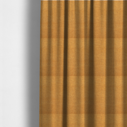 The fabric used to create these made-to-measure curtains is a finely textured weave in a rich mustard yellow or golden-amber shade. The material features a subtle heathered look with finely blended threads of warm yellow and darker neutral undertones throughout.