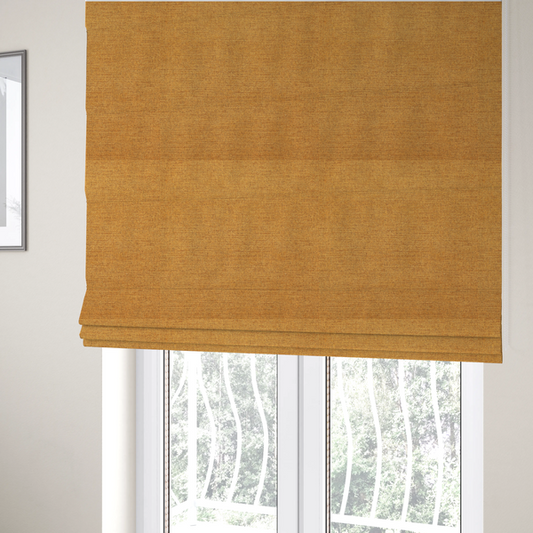 the fabric used to create these Roman blinds is a finely textured weave in a rich mustard yellow or golden-amber shade. The material features a subtle heathered look with finely blended threads of warm yellow and darker neutral undertones throughout.