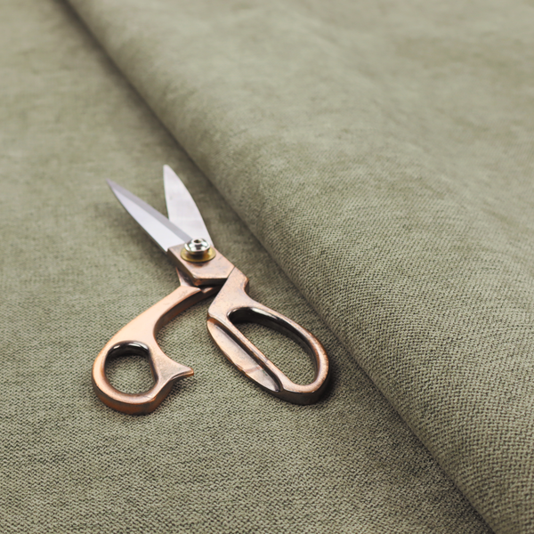 A finely textured weave in a muted sage, olive, or light moss green shade. The material features a subtle heathered look with finely blended threads of earthy green and darker neutral undertones throughout.