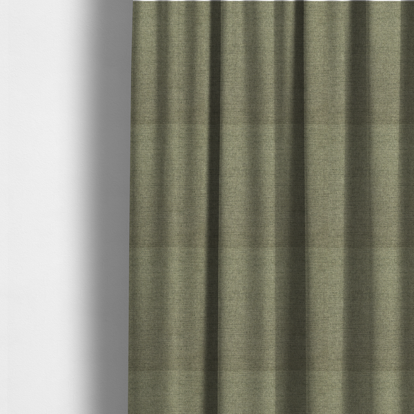 The fabric used to create these made-to-measure curtains is a finely textured weave in a muted sage, olive, or light moss green shade. The material features a subtle heathered look with finely blended threads of earthy green and darker neutral undertones throughout.