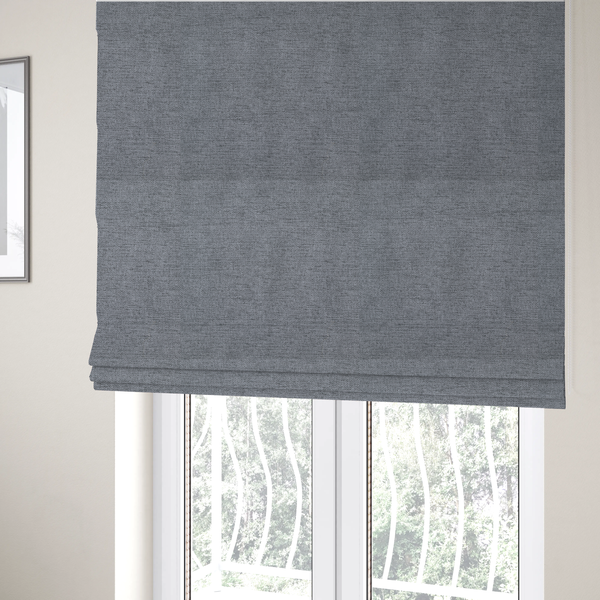 The fabric used to create these Roman blinds is a  finely textured weave in a medium steel grey or slate grey shade. The material features a subtle heathered look with finely blended threads of cool grey, soft charcoal, and muted blue-grey tones throughout.
