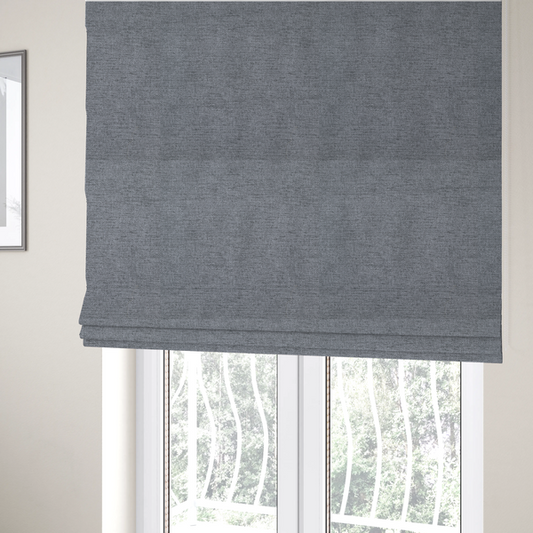 The fabric used to create these Roman blinds is a  finely textured weave in a medium steel grey or slate grey shade. The material features a subtle heathered look with finely blended threads of cool grey, soft charcoal, and muted blue-grey tones throughout.