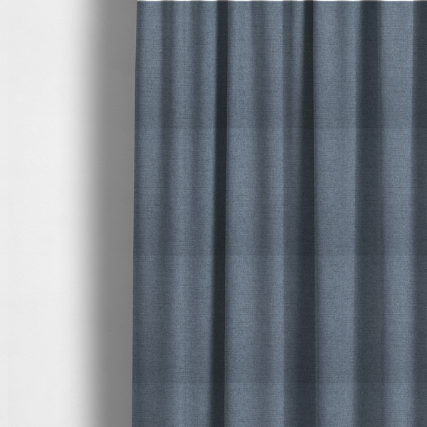 The fabric used to create these made-to-measure curtains is a finely textured weave in a soft denim, slate blue, or pigeon blue shade. The material features a subtle heathered look with finely blended threads of muted blue and cool grey undertones throughout.