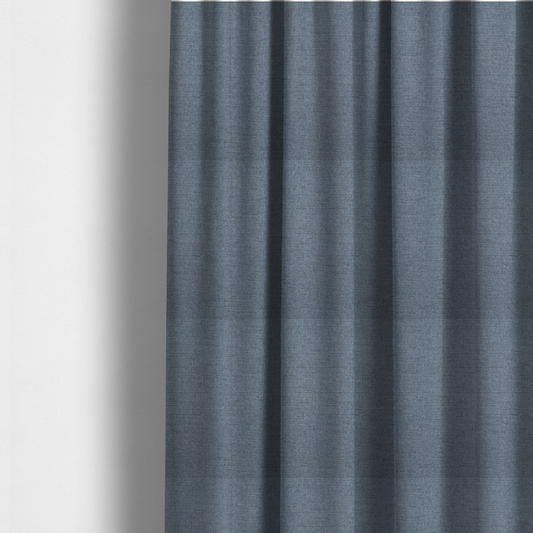 The fabric used to create these made-to-measure curtains is a finely textured weave in a soft denim, slate blue, or pigeon blue shade. The material features a subtle heathered look with finely blended threads of muted blue and cool grey undertones throughout.
