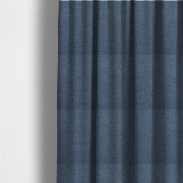 The fabric used to create these made-to-measure curtains is a finely textured weave in a rich mid-blue, ocean blue, or deep slate blue shade. The material features a subtle heathered look with finely blended threads of classic blue and darker grey undertones throughout.