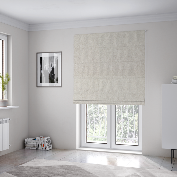 The fabric used to create these Roman blinds is a finely textured weave in a pale cream, ivory, or oatmeal shade. The material features a subtle heathered look with finely blended threads of soft white and light neutral beige undertones throughout.