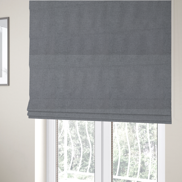 The fabric used to create these Roman blinds is a finely textured weave in a medium mineral grey or cool slate shade. The material features a subtle heathered look with finely blended threads of classic grey, white, and faint charcoal undertones throughout.