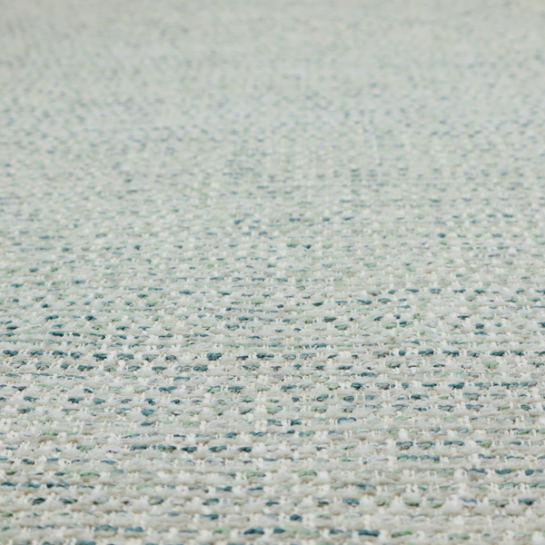 The material features a dense, multi-toned weave with a light cream or off-white background, intricately interlaced with horizontal flecks of teal, mint green, and soft grey threads throughout.