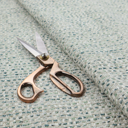 The material features a dense, multi-toned weave with a light cream or off-white background, intricately interlaced with horizontal flecks of teal, mint green, and soft grey threads throughout.