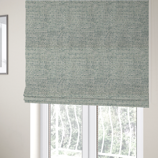 The fabric used to create these Roman blinds is a material features a dense, multi-toned weave with a light cream or off-white background, intricately interlaced with horizontal flecks of teal, mint green, and soft grey threads throughout.