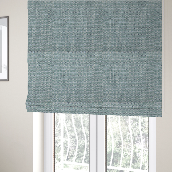 The fabric used to create these Roman blinds is a material features a dense, multi-toned weave with a soft duck egg blue and sage green base, intricately interlaced with horizontal flecks of cream and muted slate grey threads throughout.