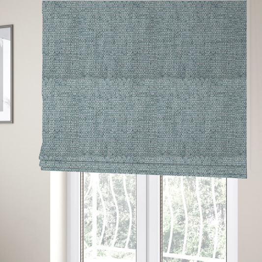 The fabric used to create these Roman blinds is a material features a dense, multi-toned weave with a soft duck egg blue and sage green base, intricately interlaced with horizontal flecks of cream and muted slate grey threads throughout.