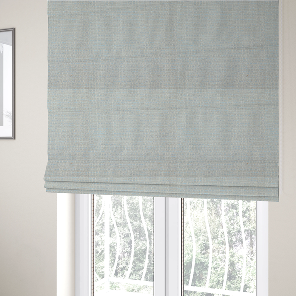 The fabric used to create these Roman blinds is a material features a dense, light-toned weave with a pale cream and off-white base, subtly interlaced with delicate horizontal flecks of soft baby blue and light grey threads throughout.