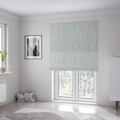 The fabric used to create these Roman blinds is a material features a dense, light-toned weave with a pale cream and off-white base, subtly interlaced with delicate horizontal flecks of soft baby blue and light grey threads throughout.