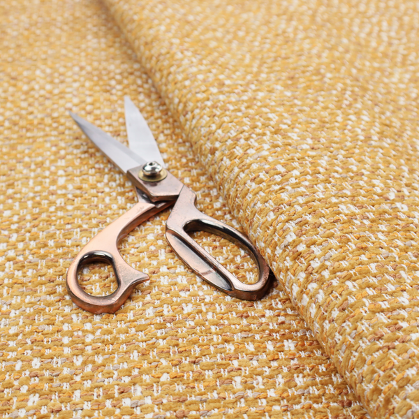 The material features a dense, multi-toned weave with a warm mustard yellow and ochre base, intricately interlaced with horizontal flecks of crisp white and soft beige threads throughout.