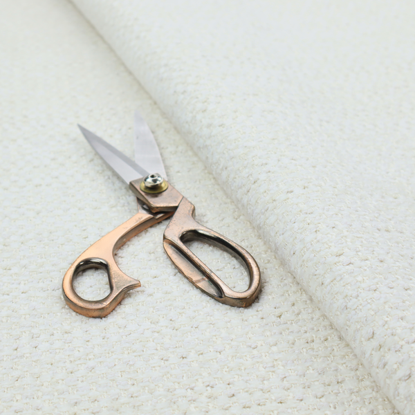 The material features a dense, minimalist weave in a uniform bright cream or off-white colour, highlighting the subtle horizontal texture of the interlaced threads.
