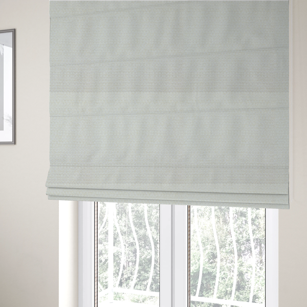 The fabric used to create these Roman blinds is a material features a dense, minimalist weave in a uniform bright cream or off-white colour, highlighting the subtle horizontal texture of the interlaced threads.