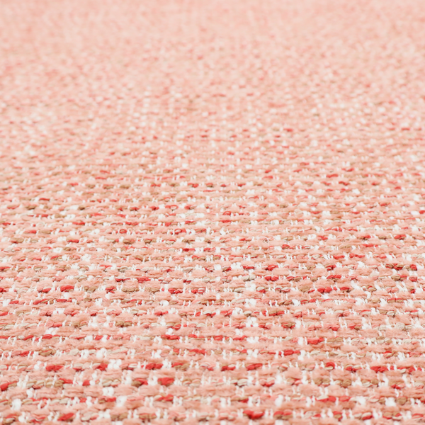The material features a dense, warm-toned weave with a soft coral pink and peach base, intricately interlaced with horizontal flecks of terracotta red, beige, and white threads throughout.