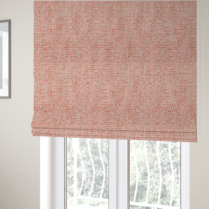 The fabric used to create these Roman blinds is a material features a dense, warm-toned weave with a soft coral pink and peach base, intricately interlaced with horizontal flecks of terracotta red, beige, and white threads throughout.