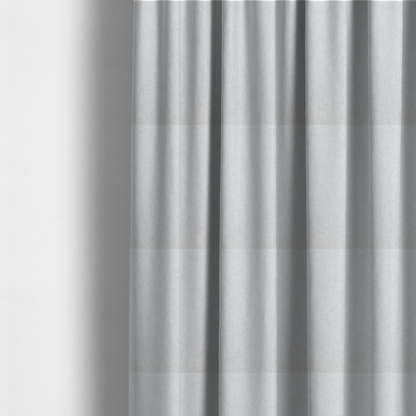 The fabric used to create these made-to-measure curtains is a light grey or off-white woven fabric with a fine, textured basket weave pattern.