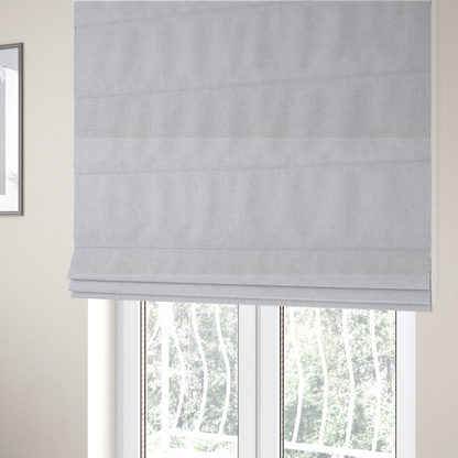 The fabric used to create these Roman blinds is a light grey or off-white woven fabric with a fine, textured basket weave pattern.