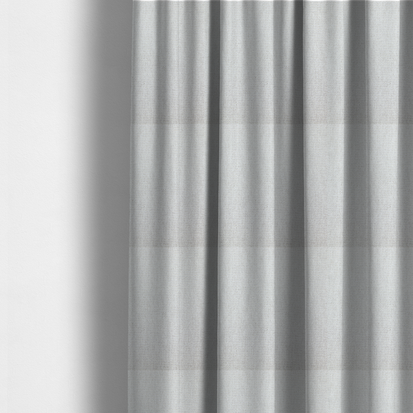 The fabric used to create these made-to-measure curtains is a lightly textured upholstery fabric in a pale cream or light grey. The material features a fine, tight weave with faint horizontal striations and a matte finish.