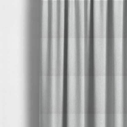 The fabric used to create these made-to-measure curtains is a lightly textured upholstery fabric in a pale cream or light grey. The material features a fine, tight weave with faint horizontal striations and a matte finish.