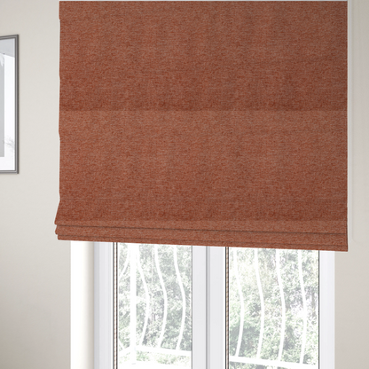 The fabric used to create these Roman blinds is a vibrant terracotta orange woven fabric with a fine, heathered texture.