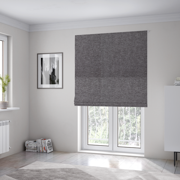 The fabric used to create these Roman blinds is a charcoal grey woven fabric with a fine, heathered texture.