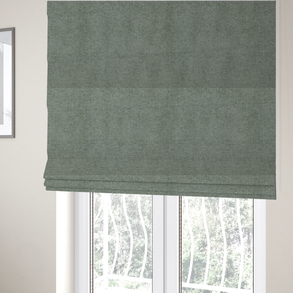 The fabric used to create these Roman blinds is a sage green woven fabric with a fine, heathered texture.