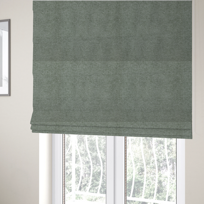 The fabric used to create these Roman blinds is a sage green woven fabric with a fine, heathered texture.