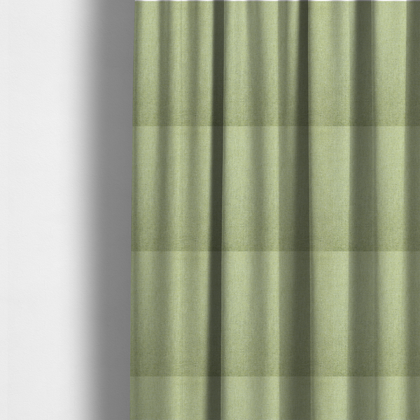 The fabric used to create these made-to-measure curtains is a light lime green woven fabric with a fine, heathered texture.