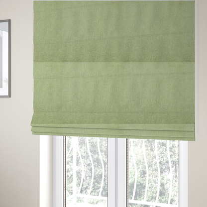The fabric used to create these Roman blinds is a light lime green woven fabric with a fine, heathered texture.