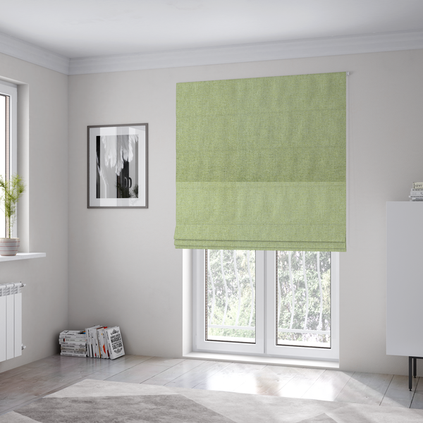 The fabric used to create these Roman blinds is a light lime green woven fabric with a fine, heathered texture.
