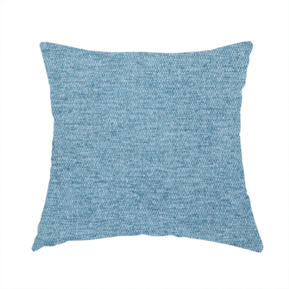 The fabric used to create this handmade cushion is a soft blue woven fabric with a fine, heathered texture.