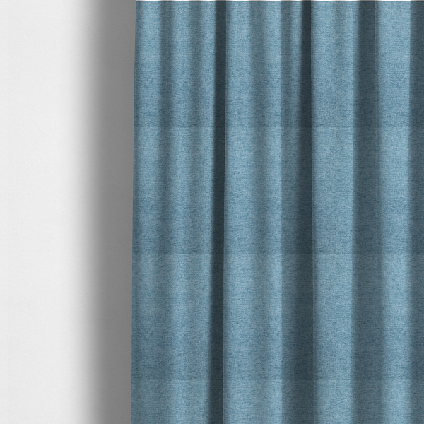 The fabric used to create these made-to-measure curtains is a soft blue woven fabric with a fine, heathered texture.