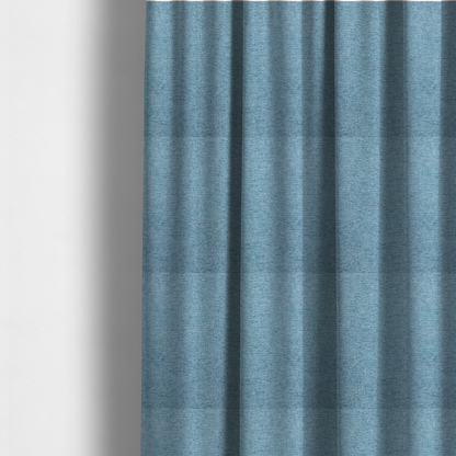 The fabric used to create these made-to-measure curtains is a soft blue woven fabric with a fine, heathered texture.
