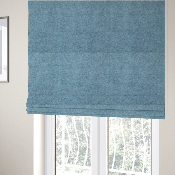 The fabric used to create these Roman blinds is a soft blue woven fabric with a fine, heathered texture.
