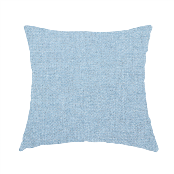 The fabric used to create this handmade cushion is a pale powder blue woven fabric with a fine, heathered texture.