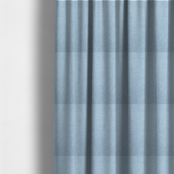 The fabric used to create these made-to-measure curtains is a pale powder blue woven fabric with a fine, heathered texture.
