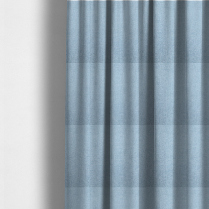 The fabric used to create these made-to-measure curtains is a pale powder blue woven fabric with a fine, heathered texture.