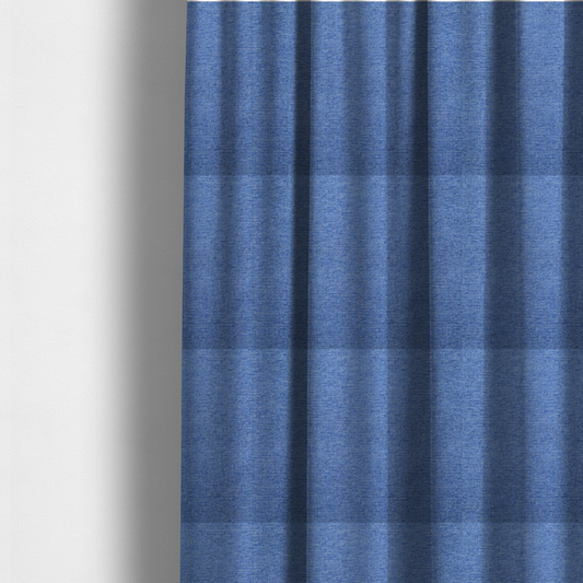 The fabric used to create these made-to-measure curtains is a vibrant mid-blue woven fabric with a fine, heathered texture.