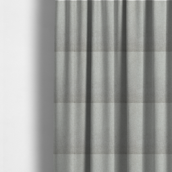 The fabric used to create these made-to-measure curtains is a light silver-grey woven fabric with a fine, heathered texture.