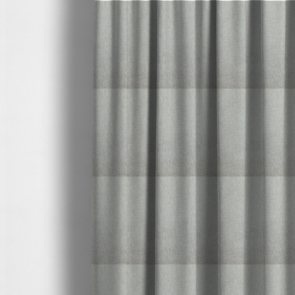 The fabric used to create these made-to-measure curtains is a light silver-grey woven fabric with a fine, heathered texture.