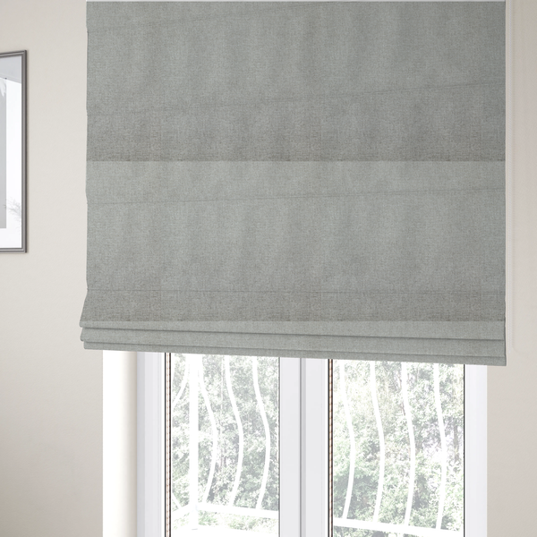 The fabric used to create these Roman blinds is a light silver-grey woven fabric with a fine, heathered texture.