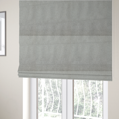 The fabric used to create these Roman blinds is a light silver-grey woven fabric with a fine, heathered texture.